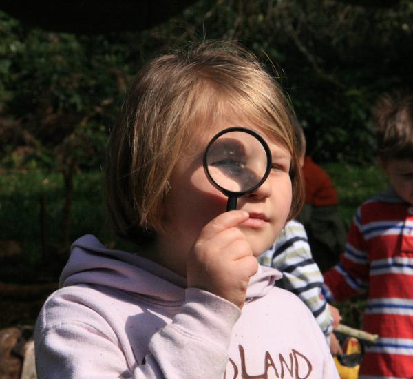 A child spying through a magnifying glass